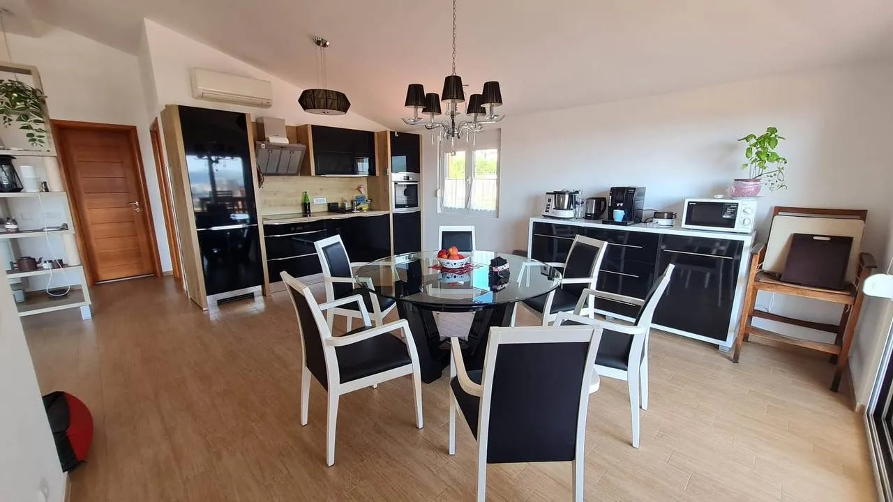 Kitchen and dining area equipped with black cabinetry and a dining table with chairs.