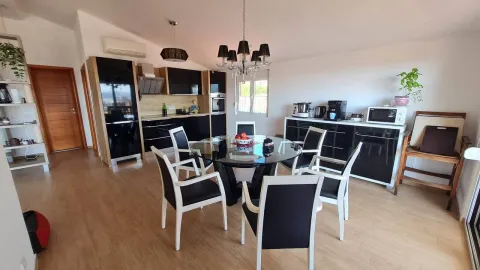 Kitchen and dining area equipped with black cabinetry and a dining table with chairs. - image 2