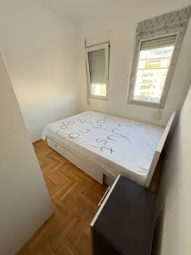 Small bedroom with a double bed, parquet flooring, and two windows. - image 6