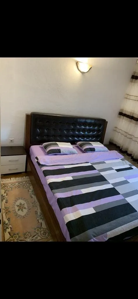 Bedroom with a double bed, nightstand, and a rug.