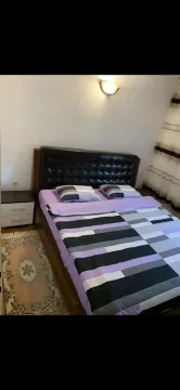 Bedroom with a double bed, nightstand, and a rug. - image 18