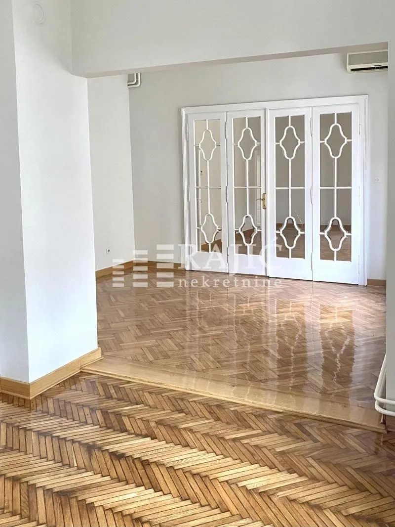 Living room with parquet flooring and white wooden doors.