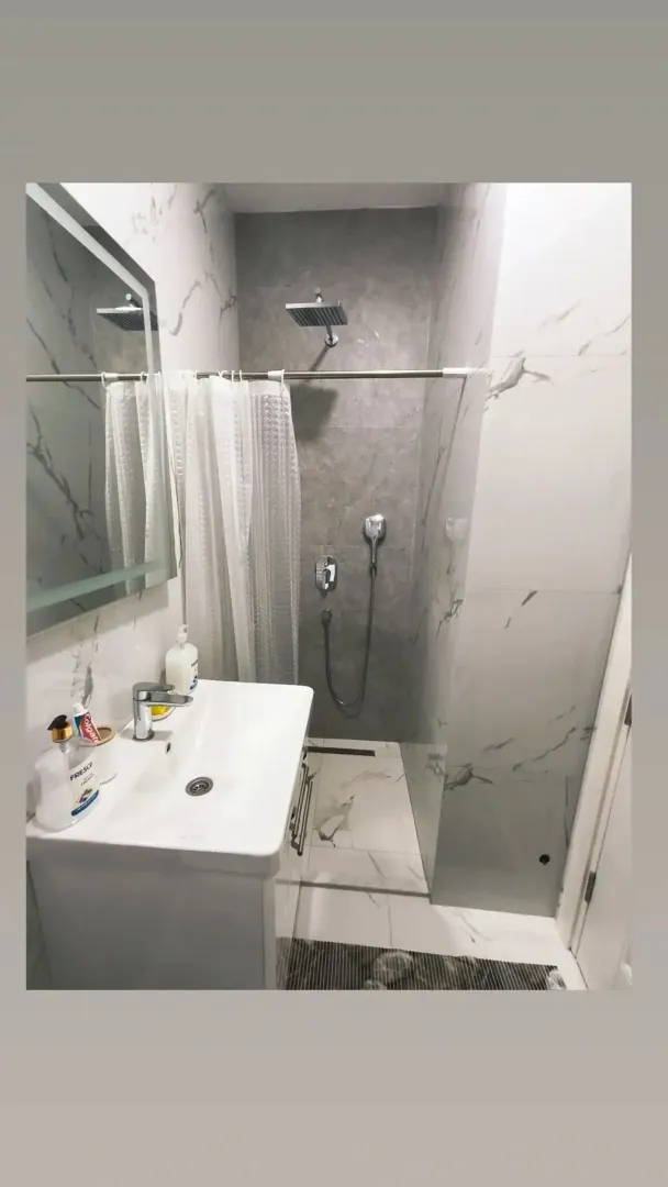 Moderne opremljeno kupatilo sa tuš kabinom i umivaonikom.