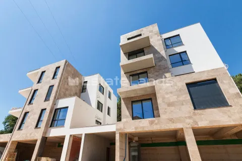 Pogled na spoljašnjost moderne stambene zgrade sa kamenom fasadom i balkonima. - image 6