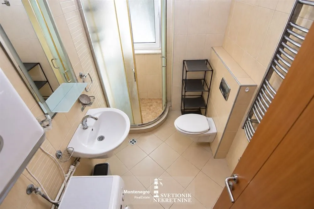 Manje kupatilo sa tuš kabinom, umivaonikom i WC šoljom.