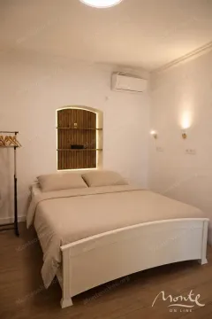 Spavaća soba sa bračnim krevetom i ugradnim policama na zidu. - image 3