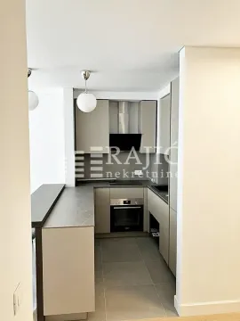 Modern kitchen with built-in appliances and a breakfast bar. - image 4