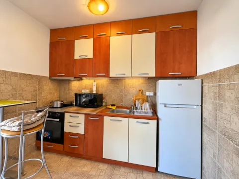 Manja kuhinja sa drvenim elementima, sudoperom, šporetom i frižiderom. - image 6