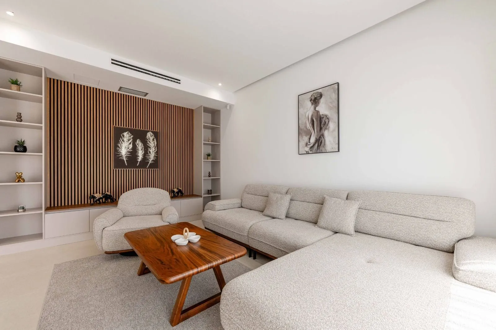 Modern living room with a sectional sofa, armchair, and wooden wall panels.