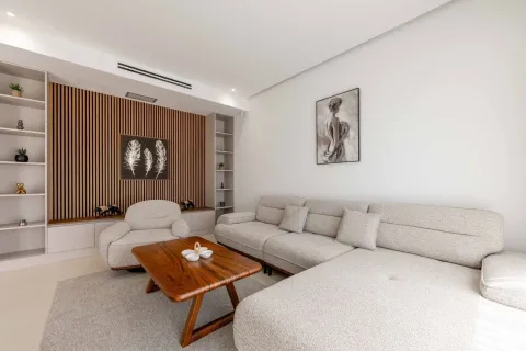 Modern living room with a sectional sofa, armchair, and wooden wall panels. - image 17