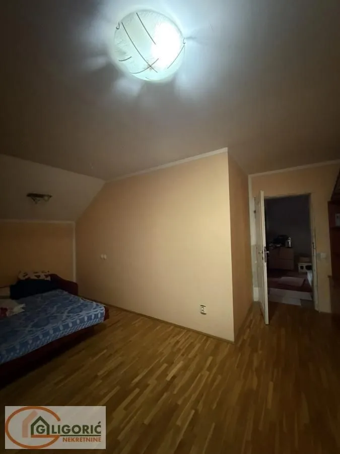Smaller bedroom with a bed and laminate flooring.