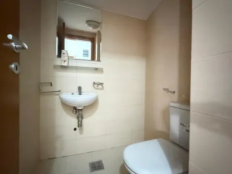 Manje kupatilo obloženo svijetlim pločicama sa umivaonikom, ogledalom i wc šoljom. - image 15