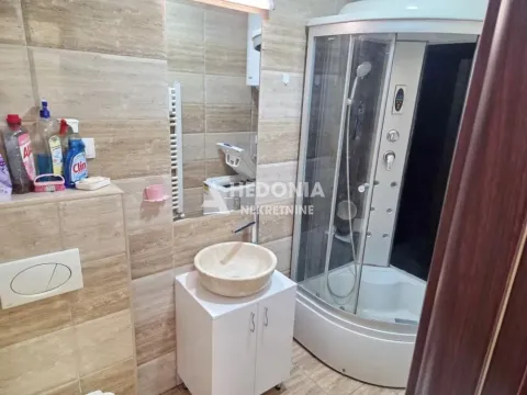 Kupatilo opremljeno umivaonikom, tuš kabinom i keramičkim pločicama. - image 8
