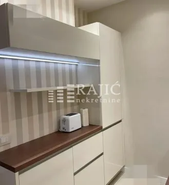 Modern kitchen with white cabinets and a wooden countertop. - image 3