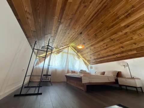 Bedroom with a wooden slanted ceiling and a double bed. - image 8