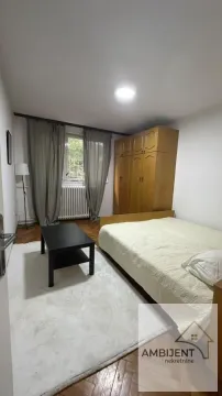 Nameštena spavaća soba sa bračnim krevetom, ormanom i prozorom. - image 6