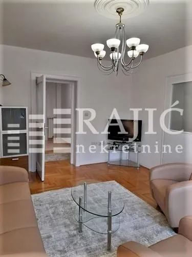 Living room with sofa set, coffee table, and TV.