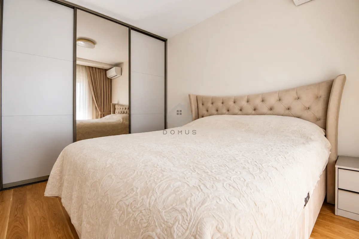 Bedroom with a large double bed and a built-in mirrored wardrobe.