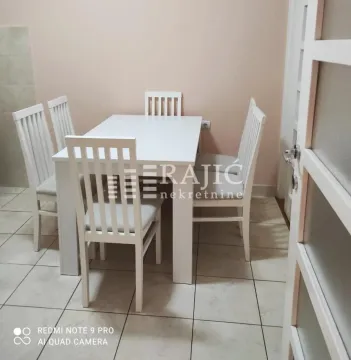 Dining room with a white table and chairs. - image 5