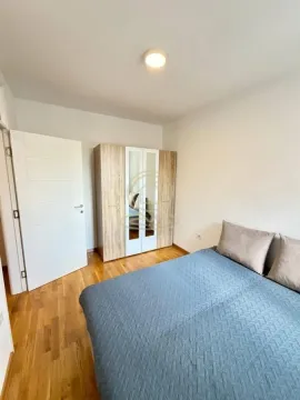 Nameštena spavaća soba sa bračnim krevetom i garderoberom. - image 6