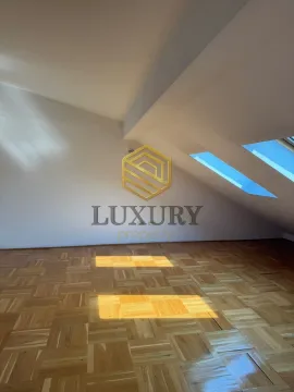 Empty attic room with parquet flooring and skylights. - image 4