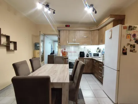 Kuhinja sa drvenim elementima i trpezarijskim stolom sa stolicama. - image 8