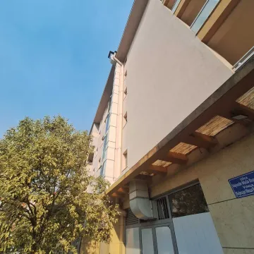 View of the exterior of the building with the facade and a tree in front. - image 5
