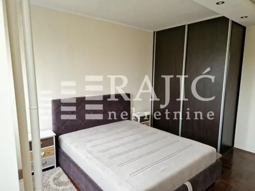 Furnished bedroom with a double bed and a fitted wardrobe.