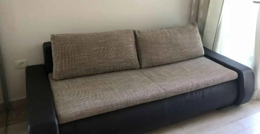 Moderna sofa u dnevnoj sobi sa sivim i crnim detaljima.