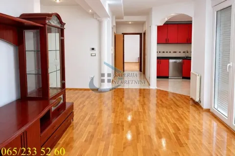 Dnevni boravak sa drvenim podom i pogledom na kuhinju u pozadini. - image 6