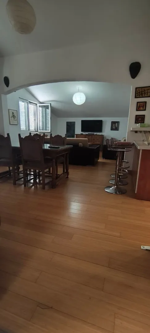 Living room with dining area and wooden flooring.