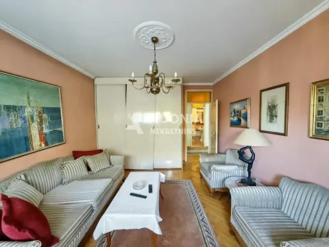 Dnevna soba sa garniturom za sedenje, klub stočićem i umetničkim slikama na zidovima. - image 7
