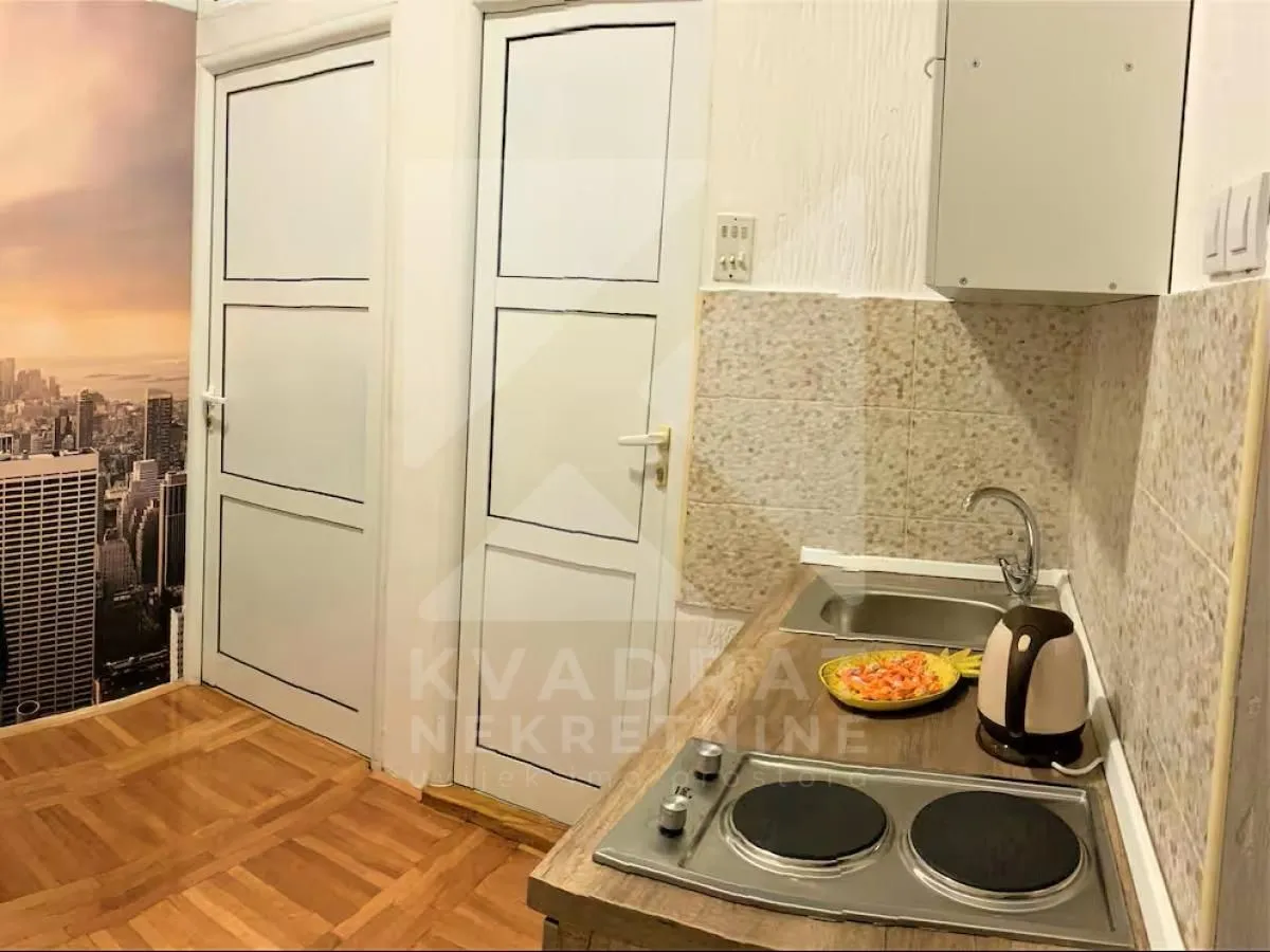 Smaller kitchen with a sink, stove, and white cabinetry.