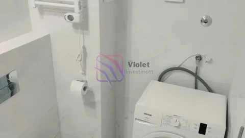 Kupatilo sa bijelim pločicama, toaletnim papirom i veš mašinom. - image 6