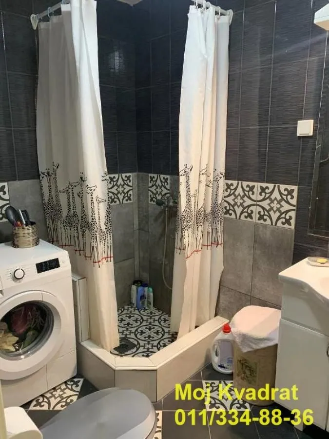 Kupatilo sa tuš kabinom, umivaonikom i veš mašinom.