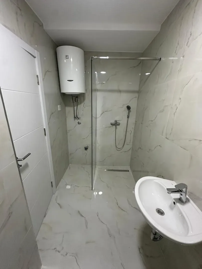 Modern bathroom with a walk-in shower and a washbasin.