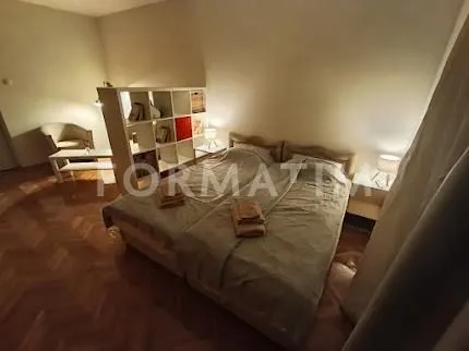 Spavaća soba sa bračnim krevetom i pregradnom policom.