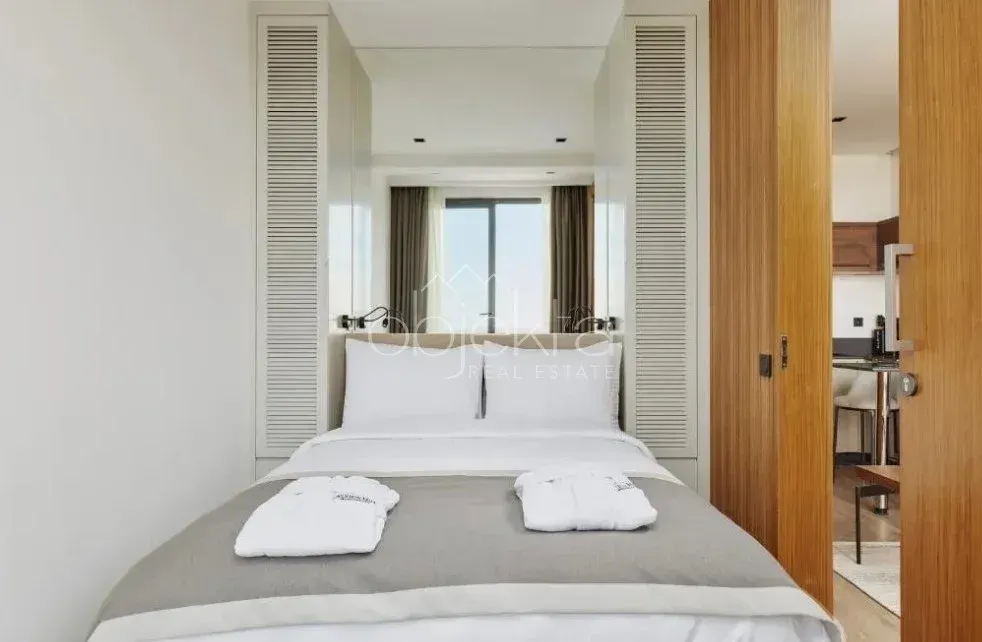 Compact bedroom with a double bed and built-in wardrobes.