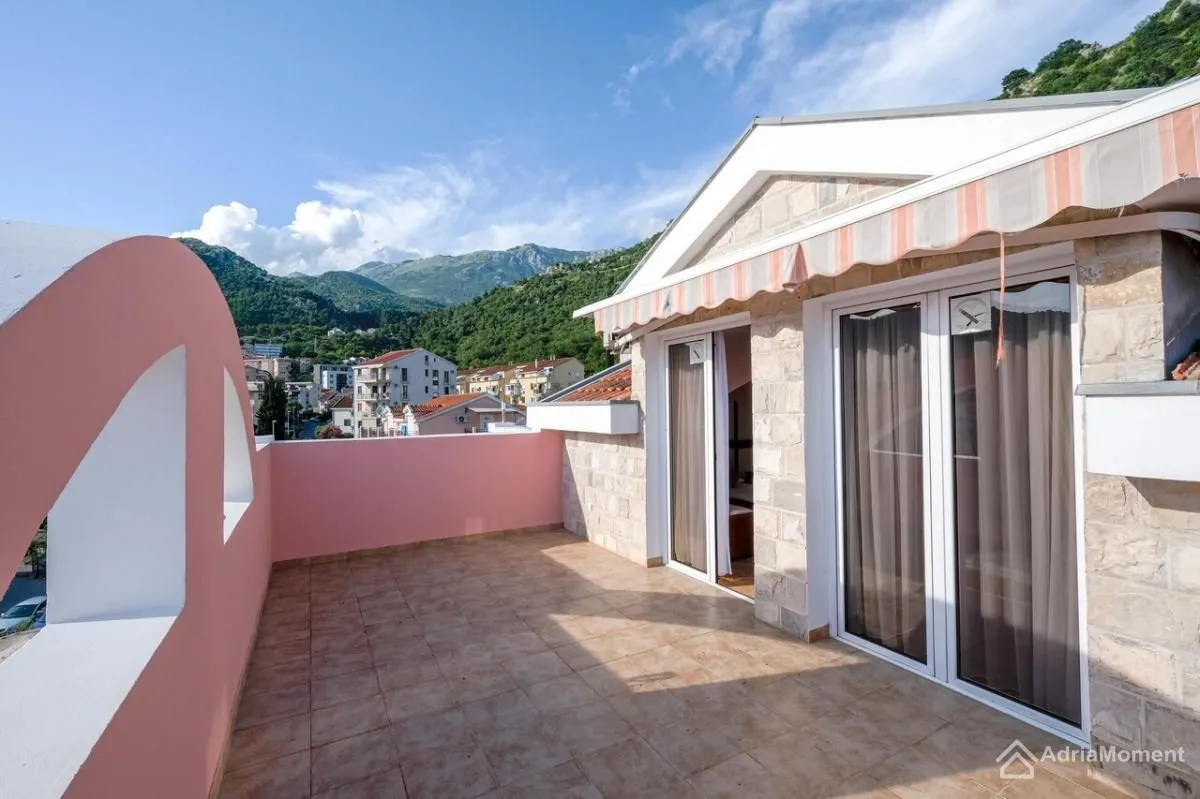Spacious terrace with tiled flooring and views of the mountains and town.