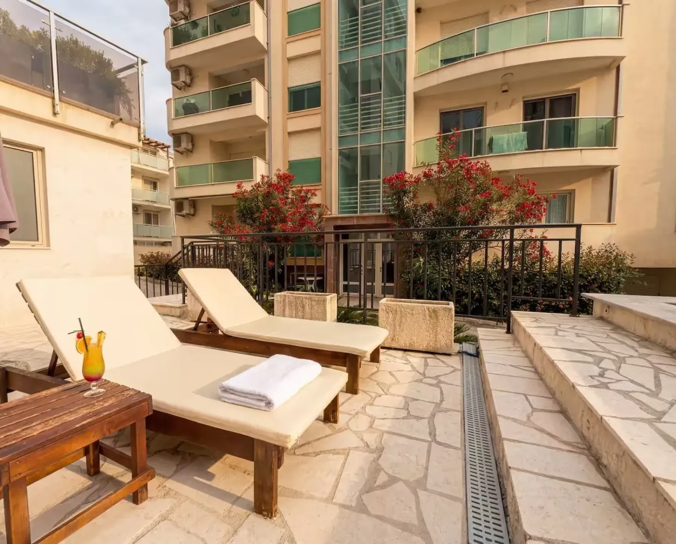 Yard with sun loungers in front of the apartment building.