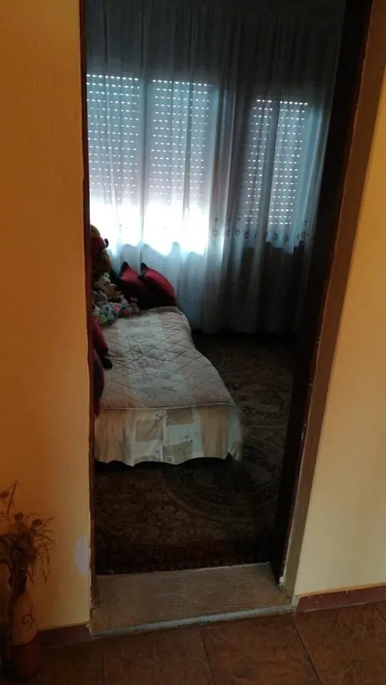 Pogled kroz vrata na spavaću sobu sa jednim krevetom.
