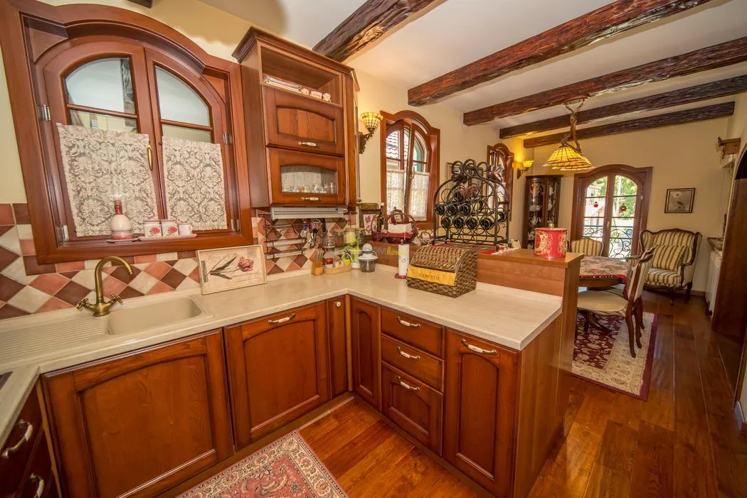 Traditional kitchen with wooden cabinetry and a dining area in the background.
