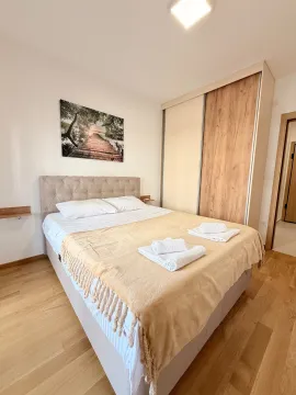 Tidy bedroom with a double bed, wardrobe, and a wall painting. - image 8