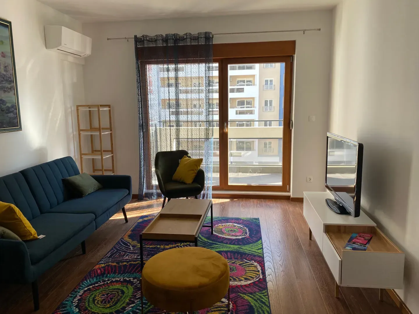 Living room with sofa, TV and access to the balcony.