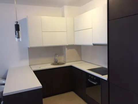 Modern kitchen with white upper cabinets, dark base cabinets and built-in appliances. - image 14