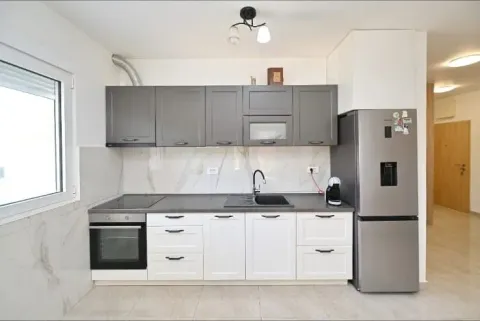 Modern kitchen with grey upper and white lower cabinets and a refrigerator. - image 5
