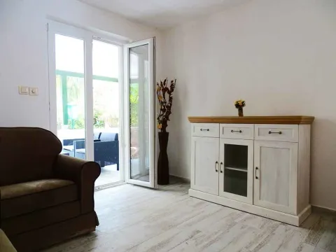 Dnevna soba sa foteljom, komodom i izlazom na terasu. - image 6