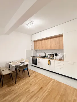 Moderna kuhinja sa bijelim i drvenim elementima i trpezarijskim stolom. - image 3