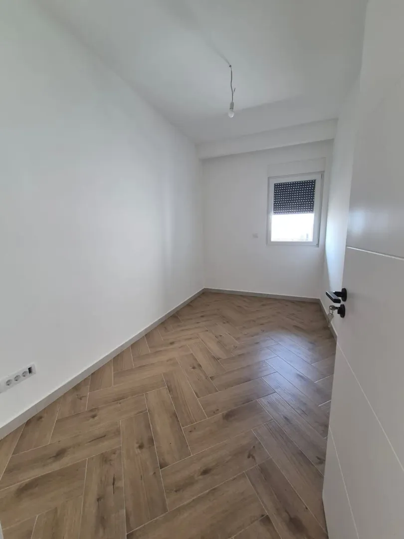 Prazna svetla soba sa drvenim podom.