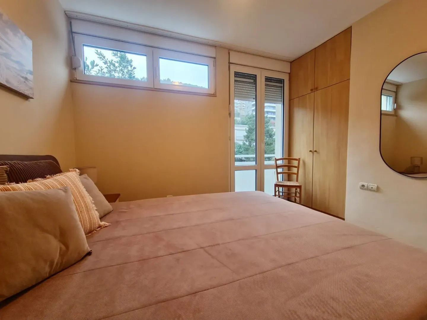 Furnished bedroom featuring a double bed, built-in wardrobe, and balcony doors.